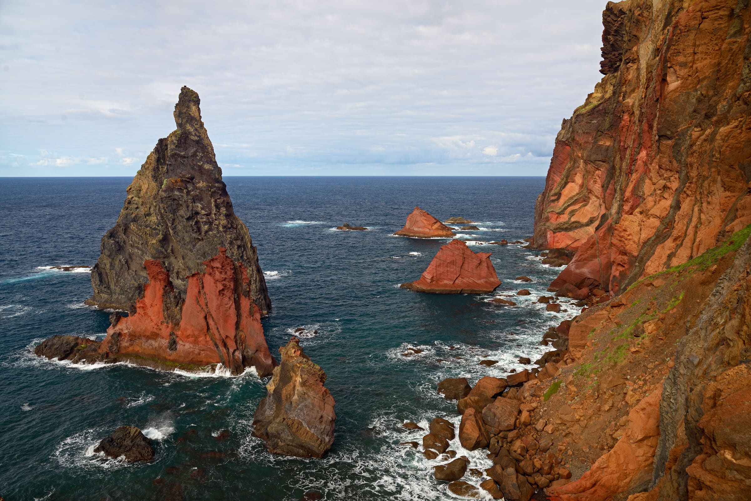 Warm evening light over the red volcanic cliffs and sea stacks of the São Lourenço peninsula, Madeira.